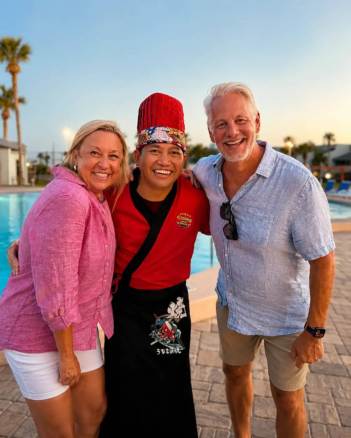 Hosts celebrating with their hibachi chef by the pool